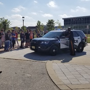 RCBC students gathered outside around a Mount Laurel police officer and vehicle