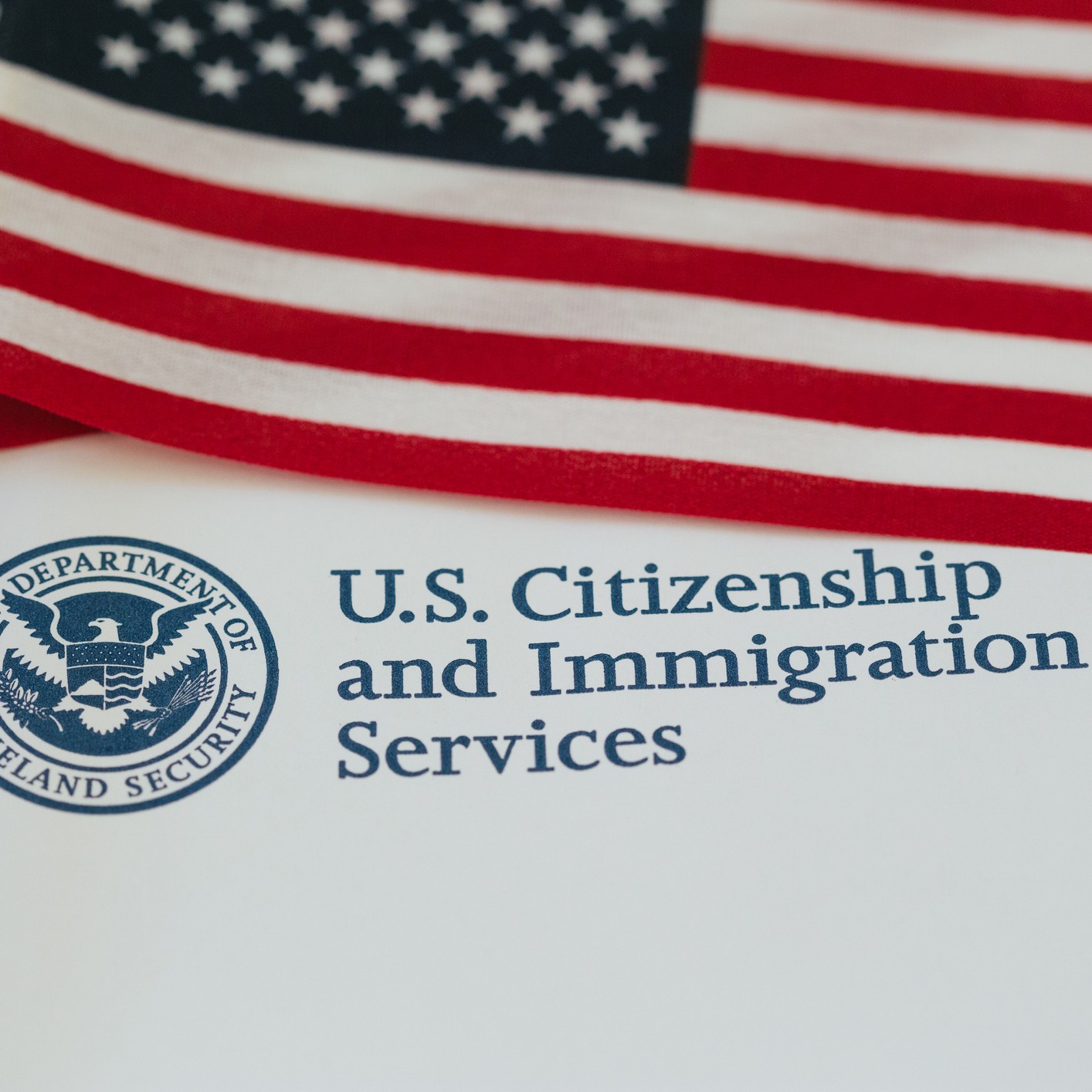 flag beside U.S. Citizenship and Immigration Services stamp